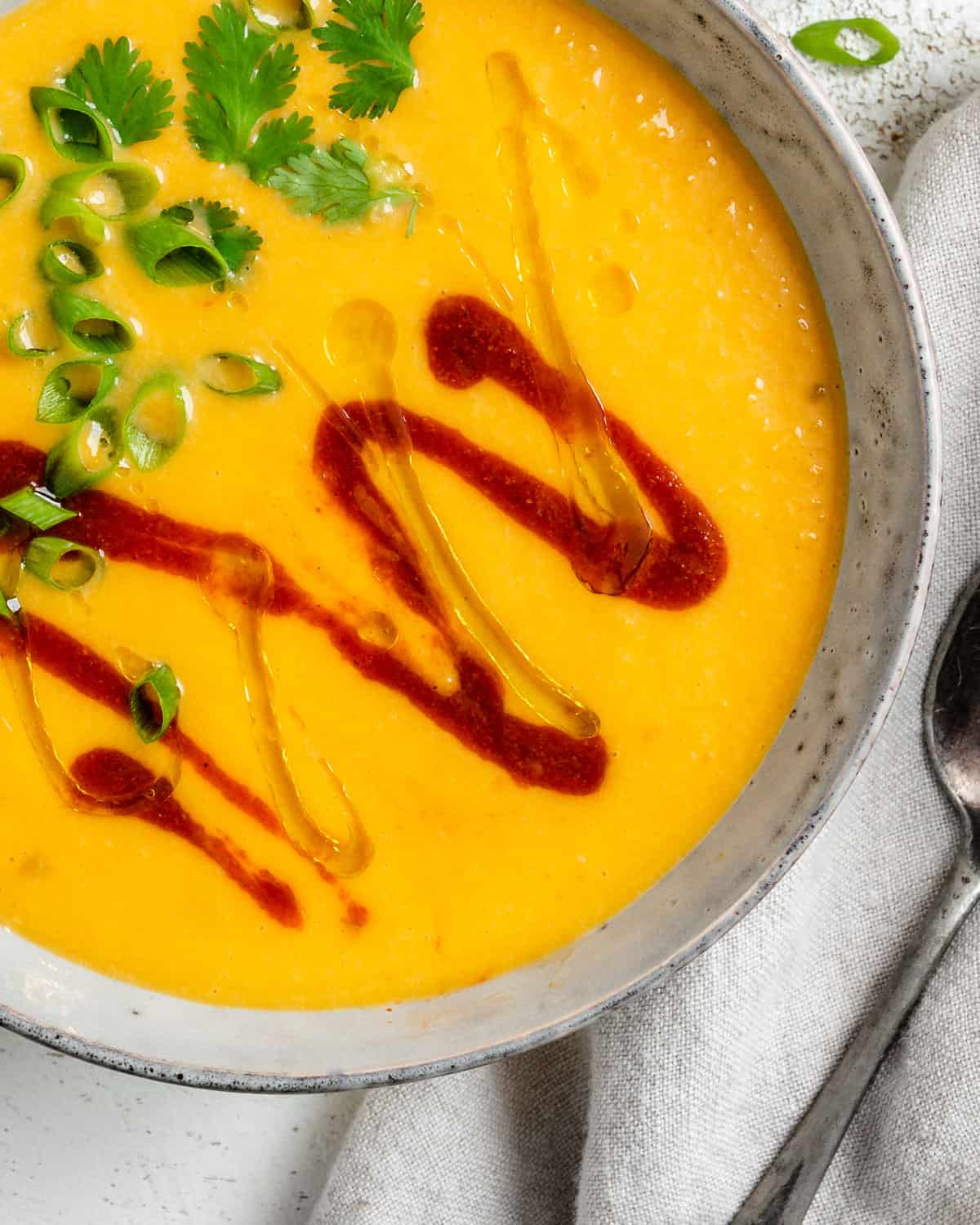 سوپ کدو حلوایی تایلندی را در یک کاسه سفید با پس زمینه سفید کامل کرد