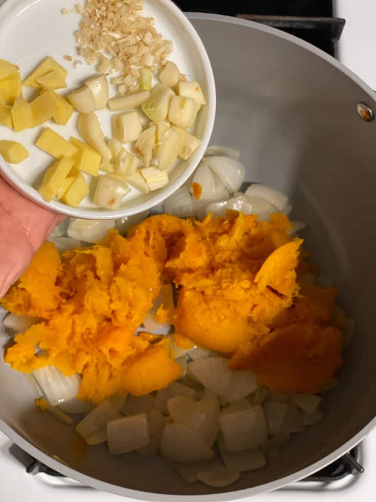 Process shot of adding garlic and ginger to the pan