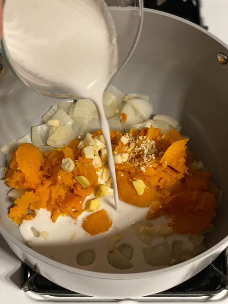 process shot of adding coconut milk to pan