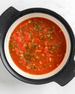 process shot of ingredients for Turkish Tomato, Bulgur, and Red Pepper Soup in a pan