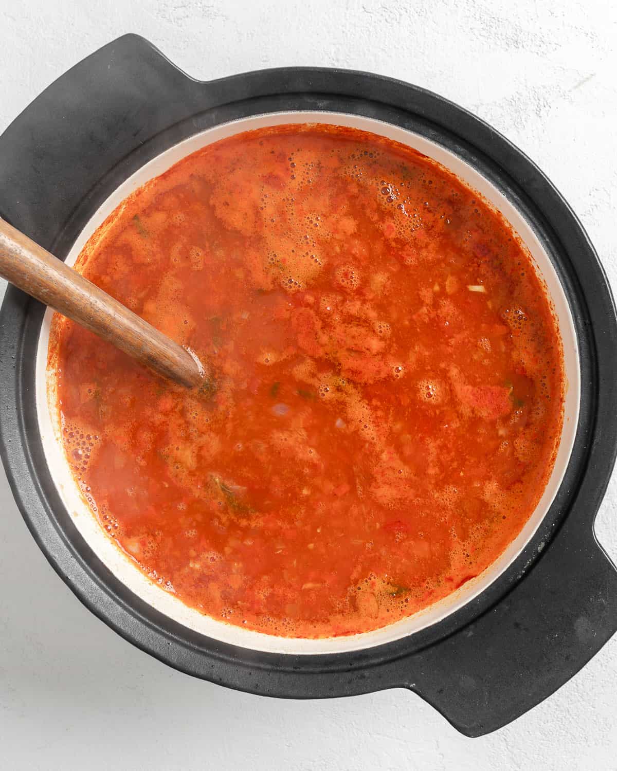 process shot of bulgar added to pot of soup