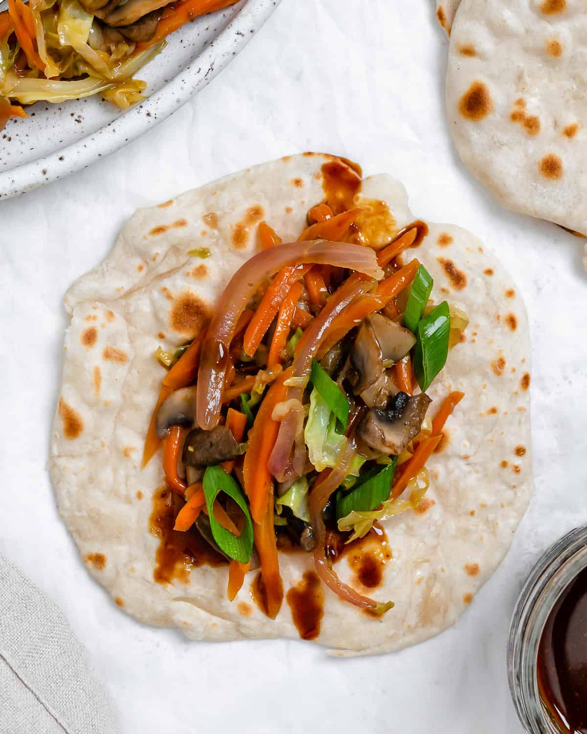 completed Moo Shu Vegetables on mandarin pancakes against a white surface