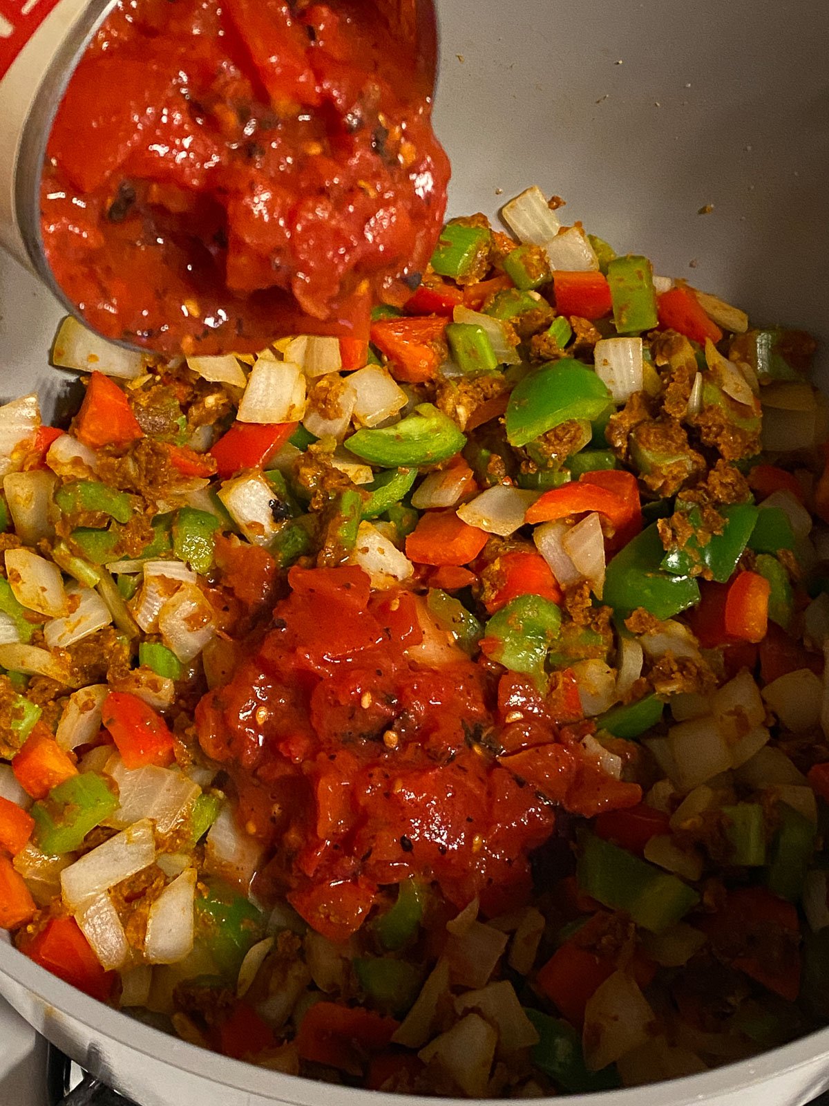 process shot of tomatoes being added into pan