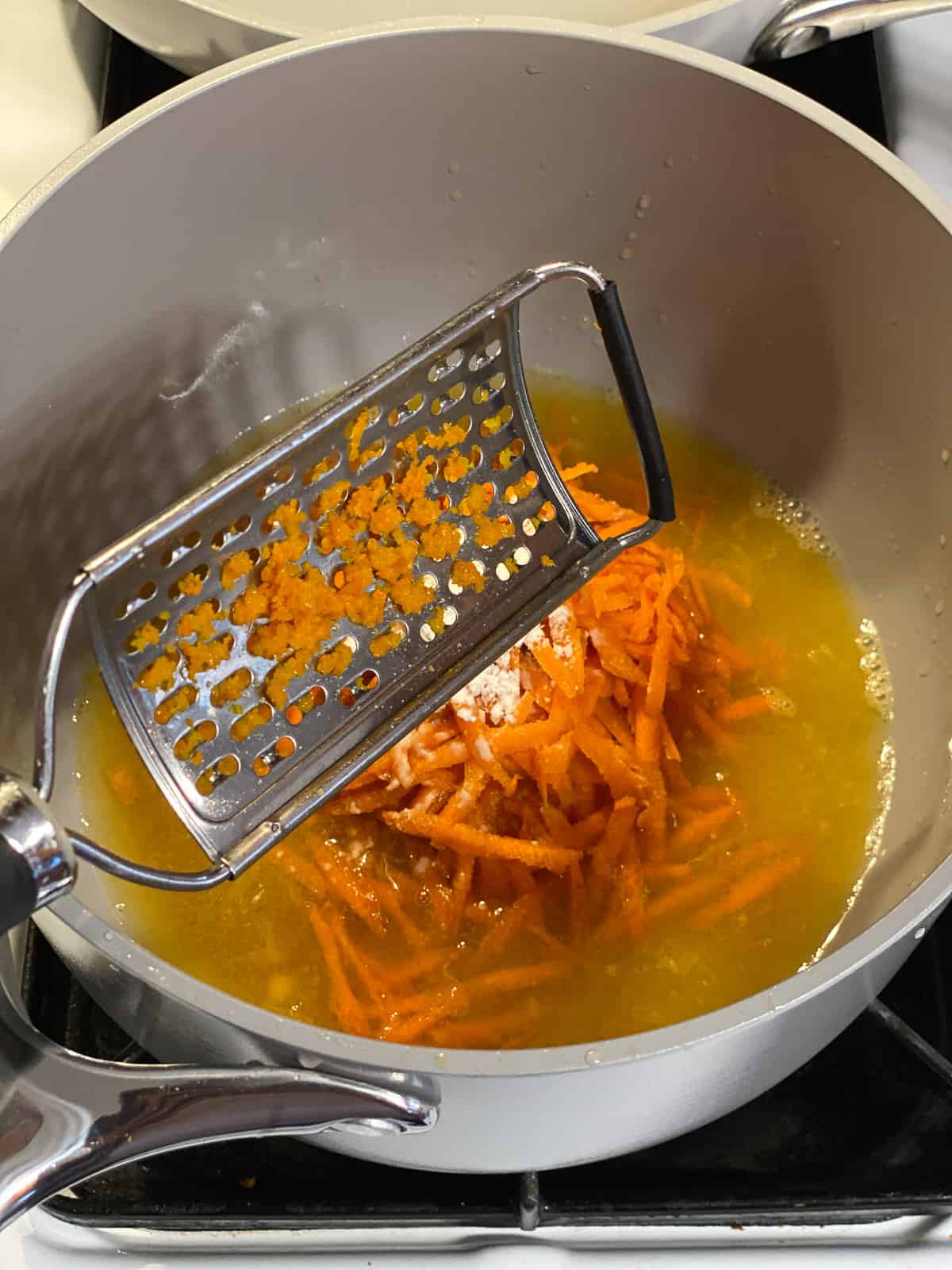 process shot of grating carrots into pan