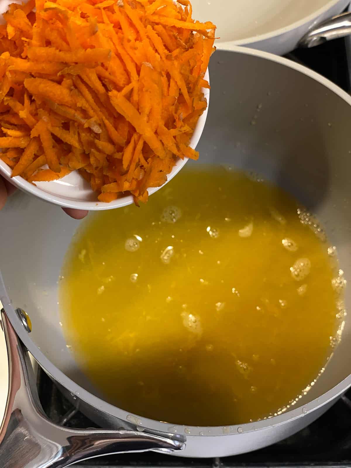 process shot of adding carrots to pan