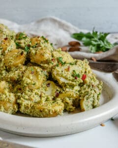 completed almond Parsley Potatoes in a white baking dish against a white background