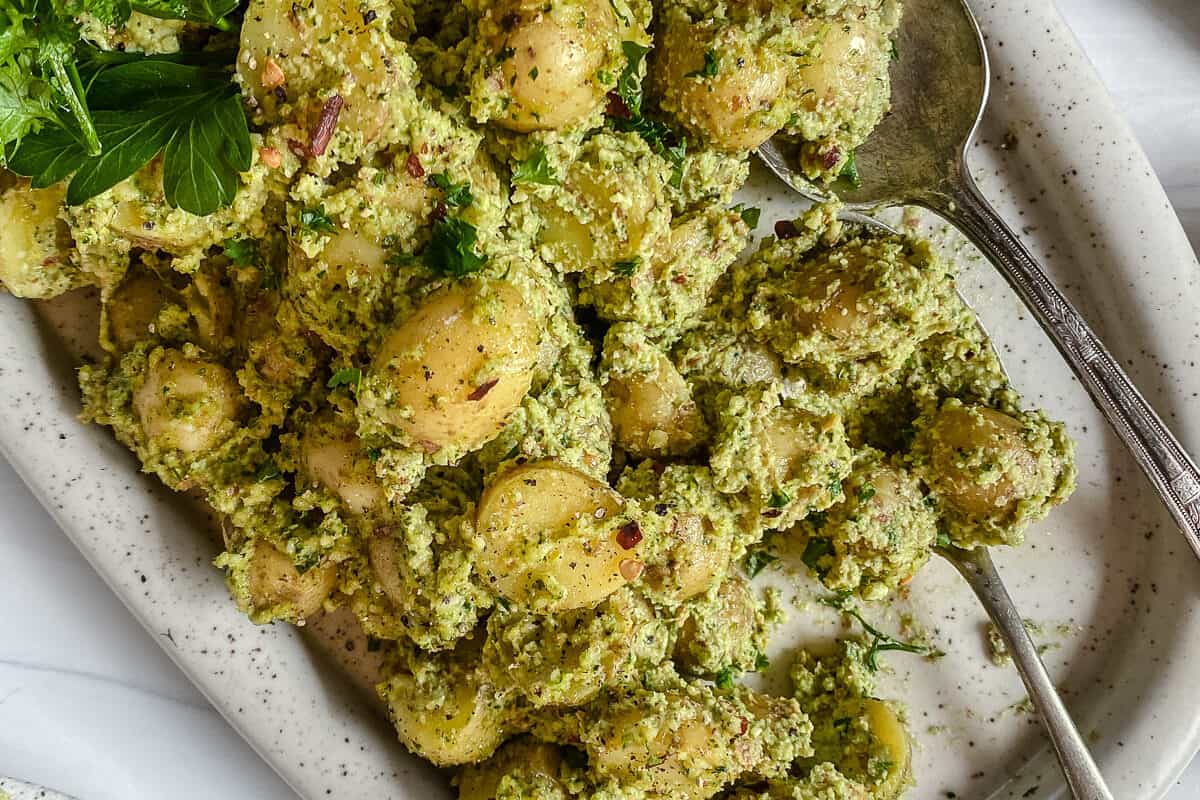 completed almond Parsley Potatoes in a white baking dish against a white background