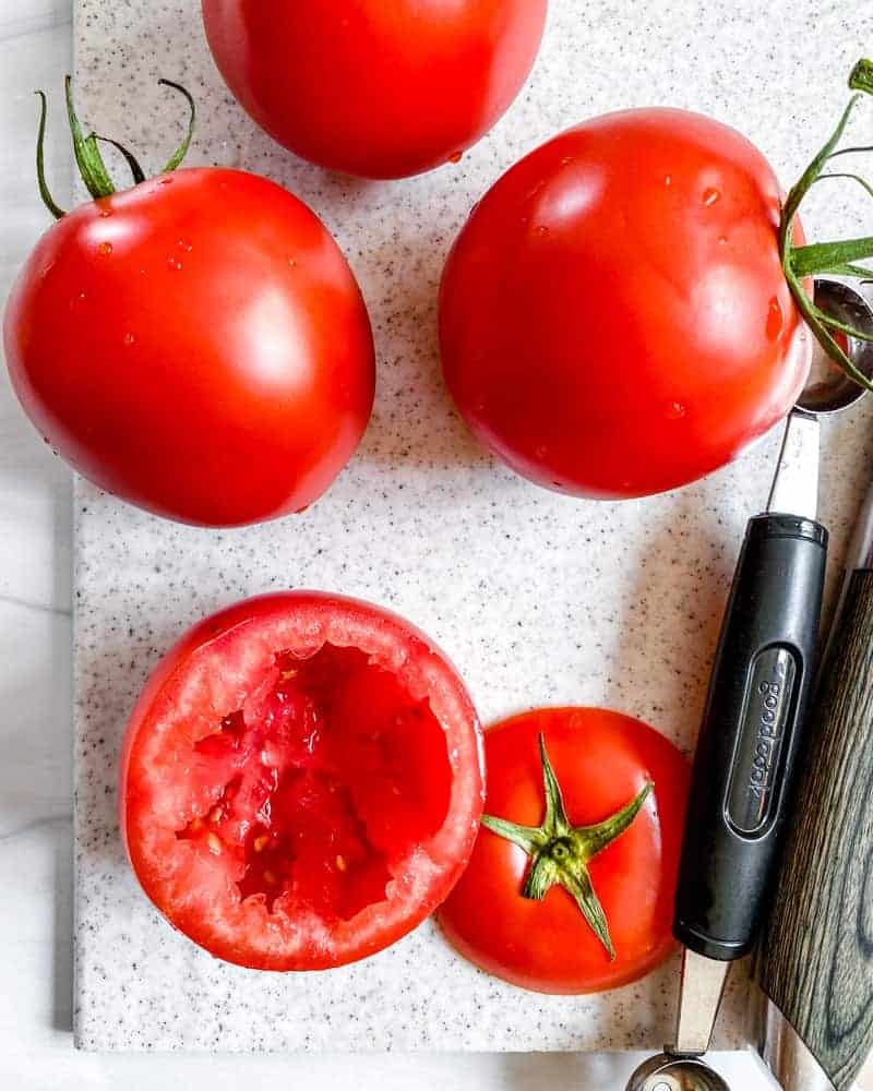 post taking out the inside of a tomato alongside two whole tomatoes