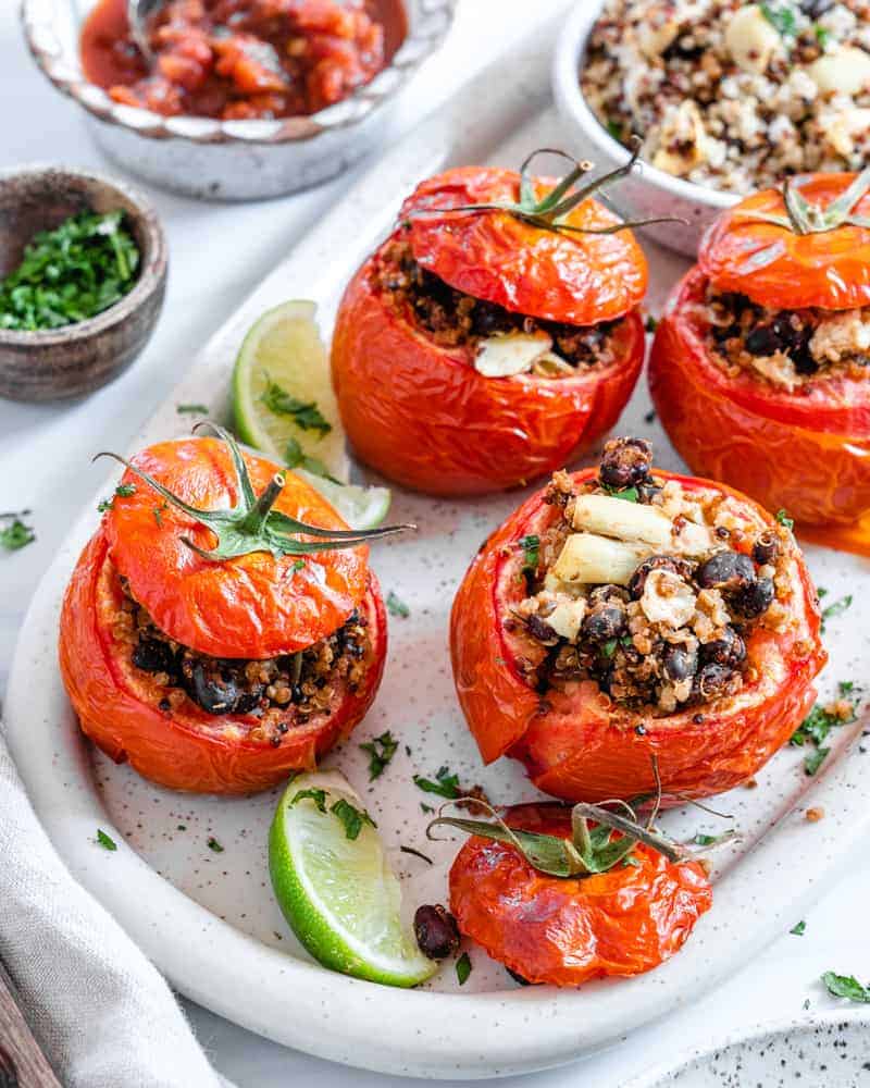 completed stuffed tomatoes plated on a white plater against a white background