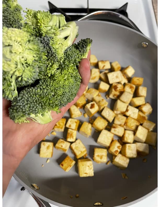 process of adding broccoli to pan