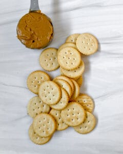 crackers and peanut butter ingredients for Peanut Butter Cracker Sandwiches on a white surface