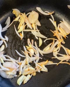 sliced veggies being added to pan