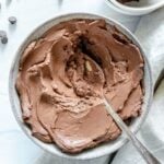 Completed Simple Chocolate Mousse in white bowl in white background with scattered chocolate chips.