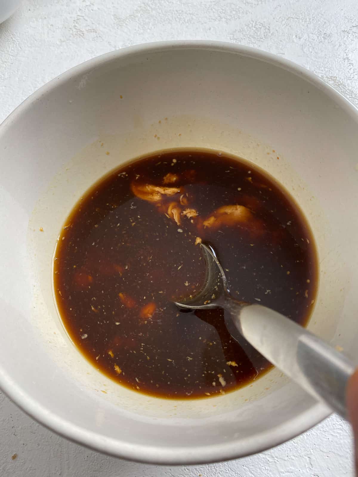 process shot of mixing sauce ingredients together in a bowl