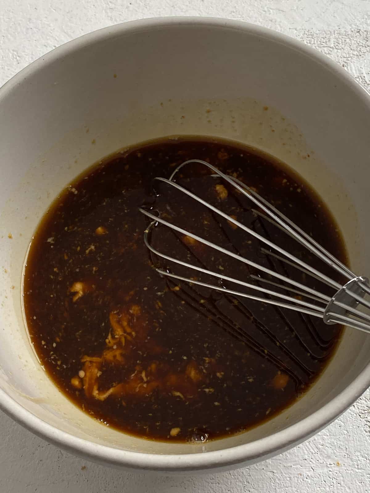process shot of mixing sauce ingredients together in a bowl