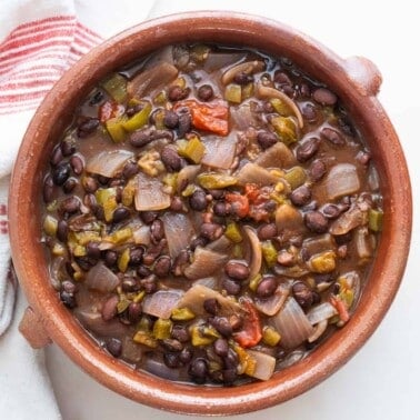 finished black bean chili in brown bowl against a white background