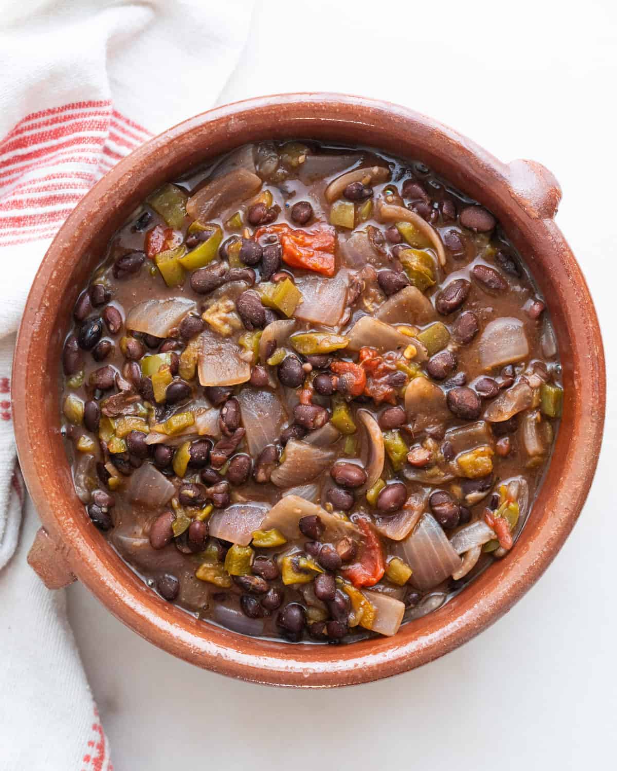 finished black bean chili in brown bowl against a white background