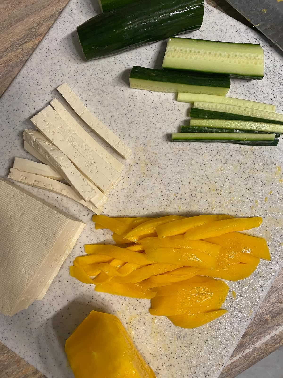 sliced ingredients for Tofu Spring Rolls With Mango and Avocado on a cutting board