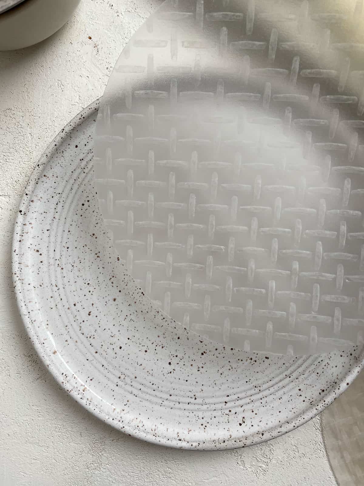 rice wrapper being dipped on top of a plate with water