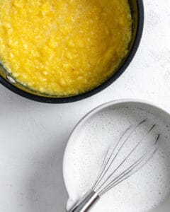 pie filling in plack pan with white bowl of ingredients on the side