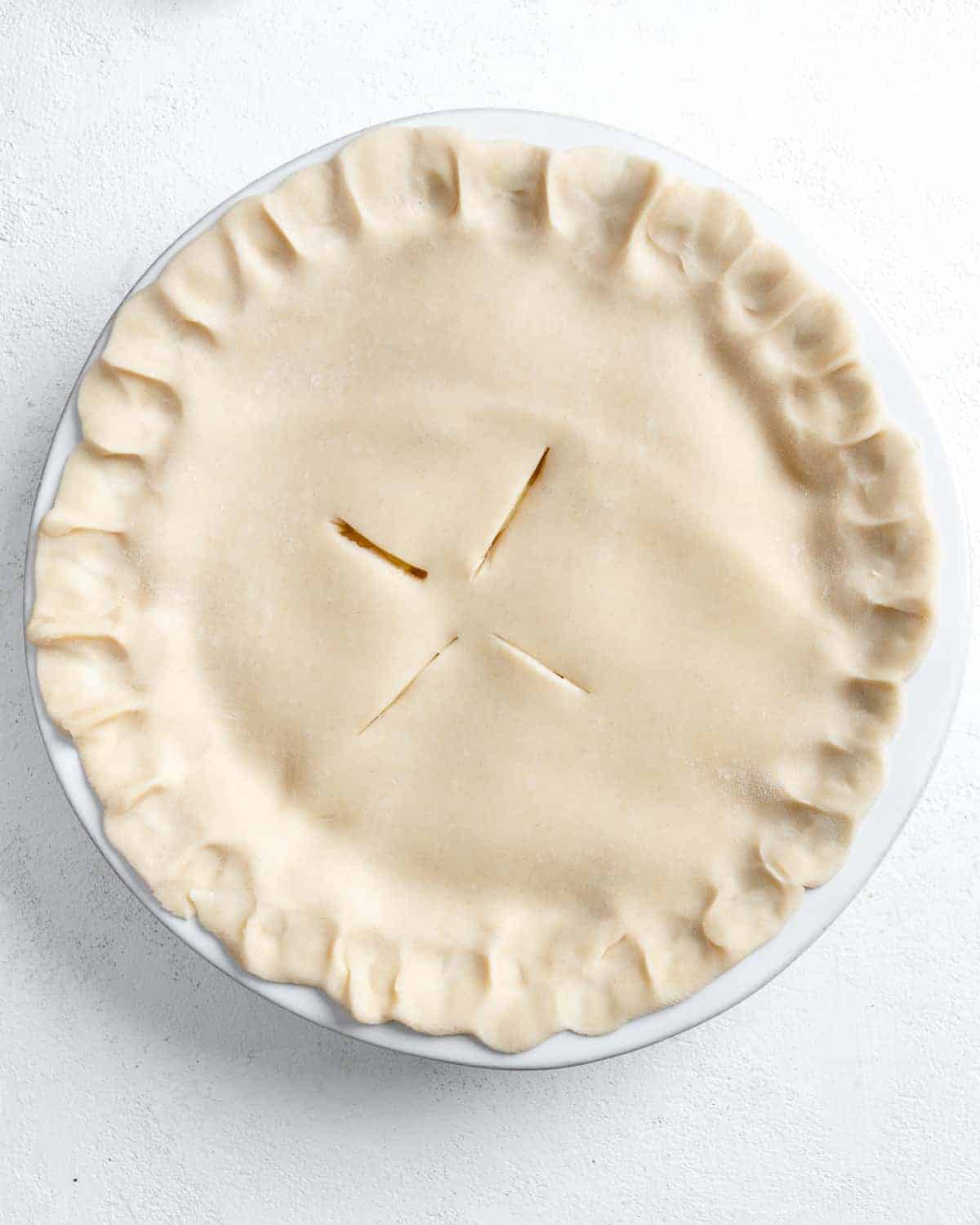 process shot of Vegan Coconut Pineapple Pie before being put in the oven against a white background