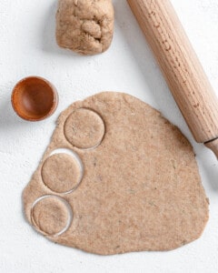 process of making circular molds in dough against a white surface