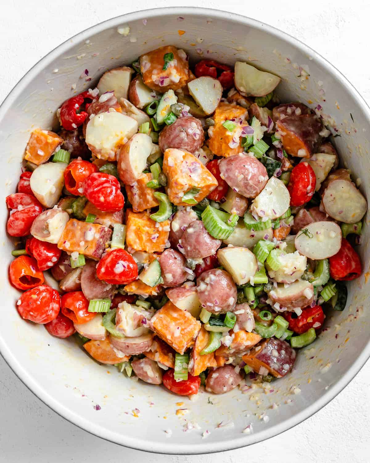 post adding dressing into bowl of Sweet Potato Salad ingredients post mixing