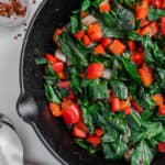 completed Spicy Collard Greens in a black pan against a white surface