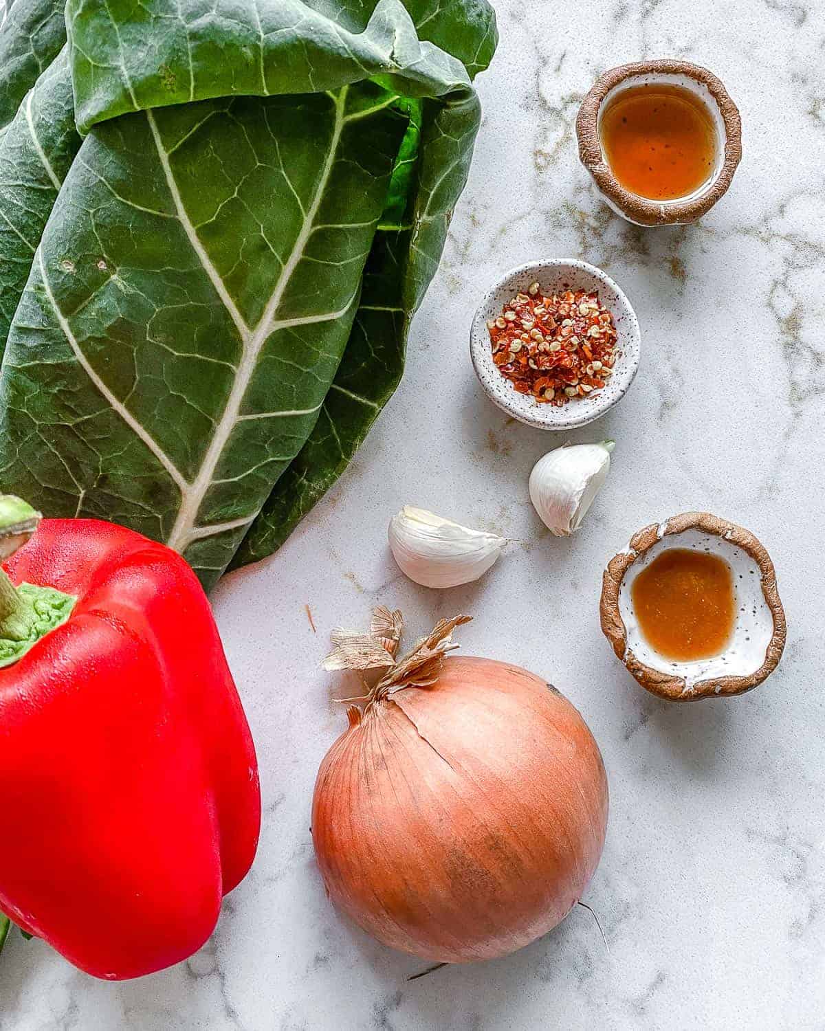 ingredients for Spicy Collard Greens measured out against a white surface