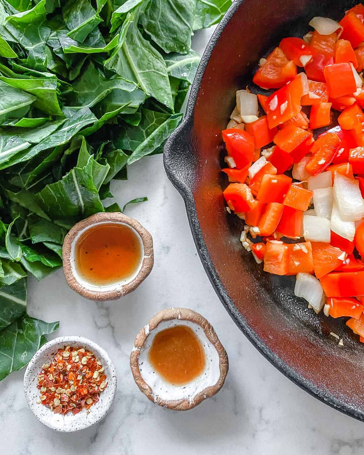 process of adding additional ingredients for Spicy Collard Greens into black skillet