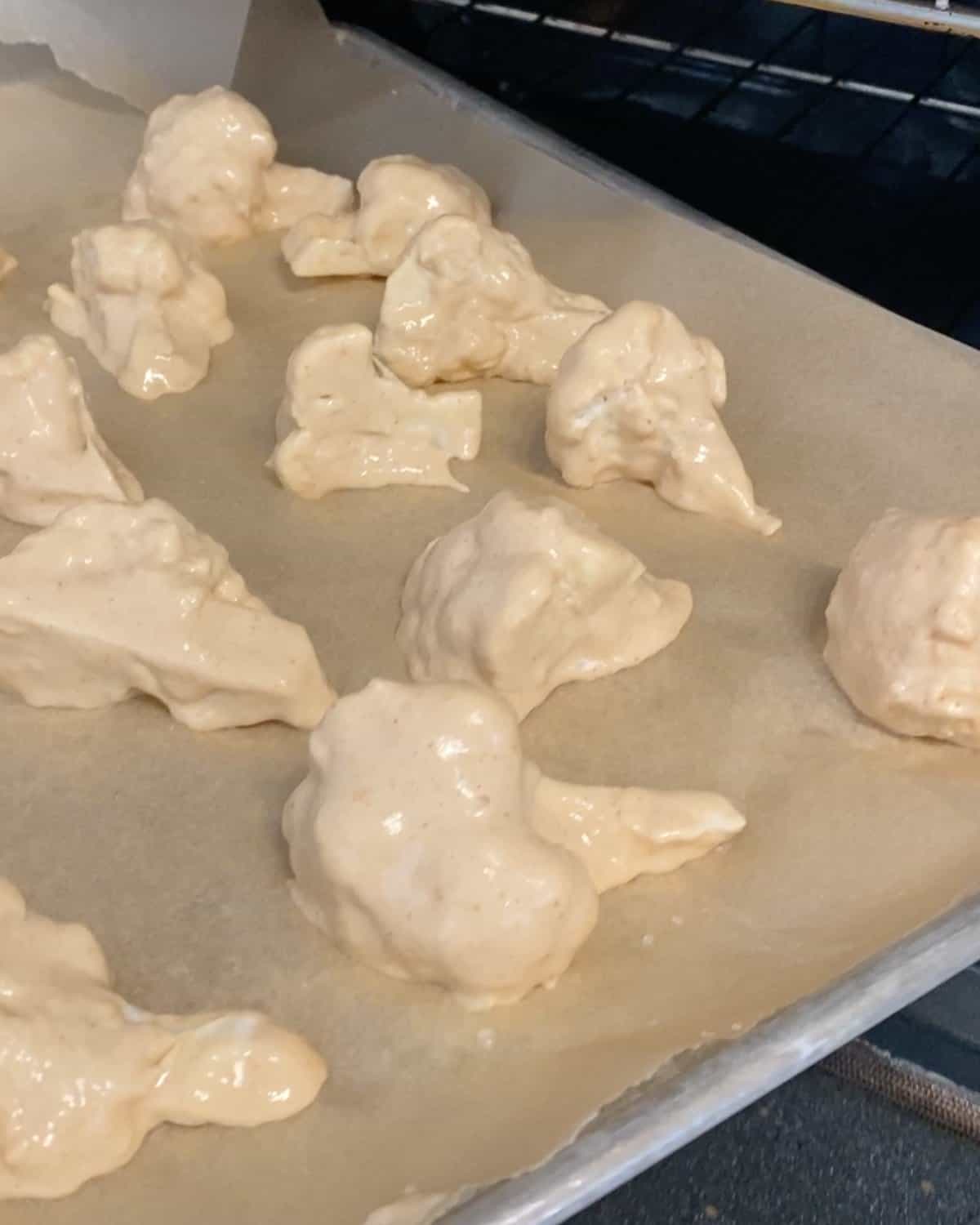 process shot showing showing cauliflower with batter on parchment paper