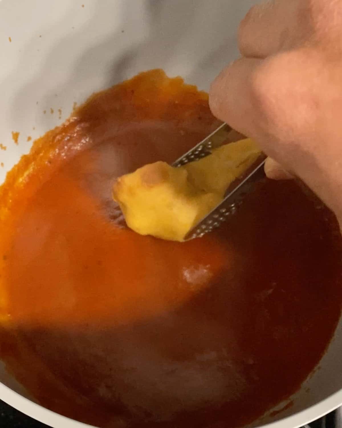 process shot of dipping cauliflower with batter into bbq sauce