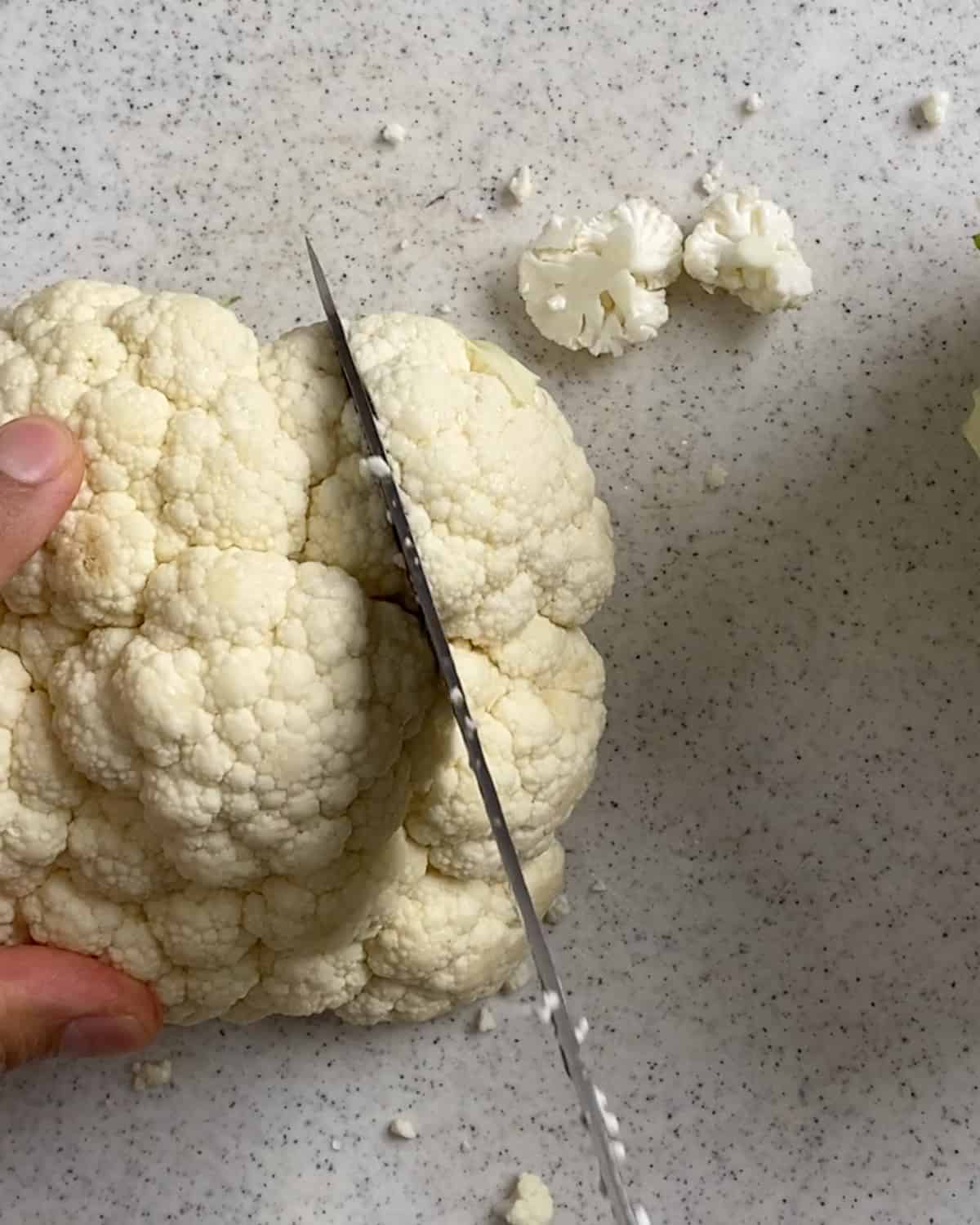process shot of cutting cauliflower against a light surface