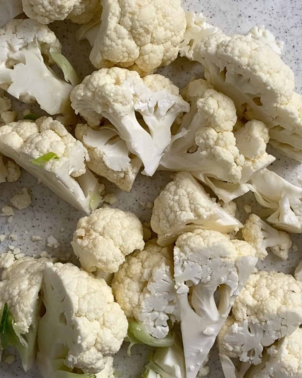 cauliflower florets cut on a light surface