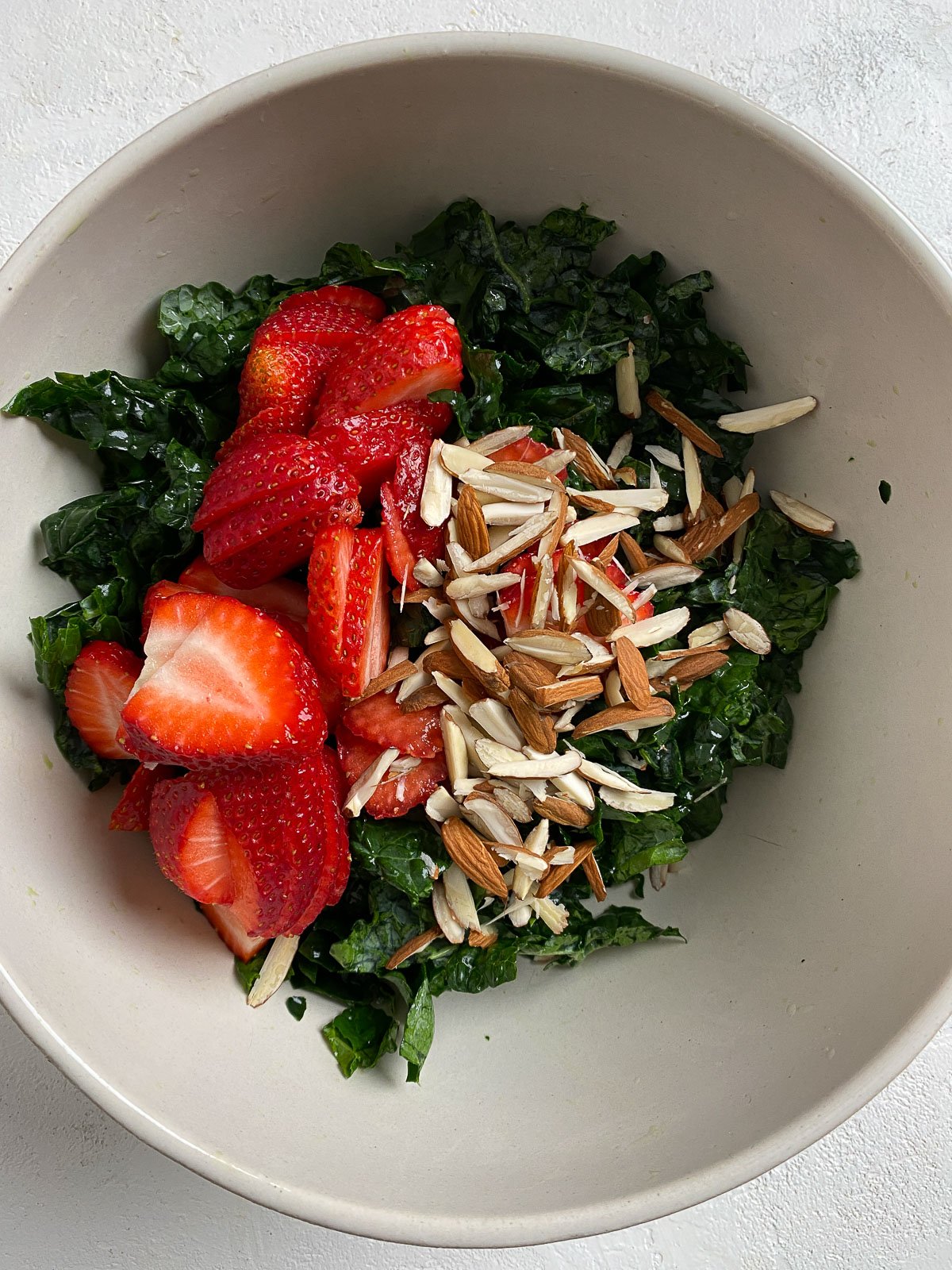 process showing addition of Strawberry Kale Salad ingredients into bowl
