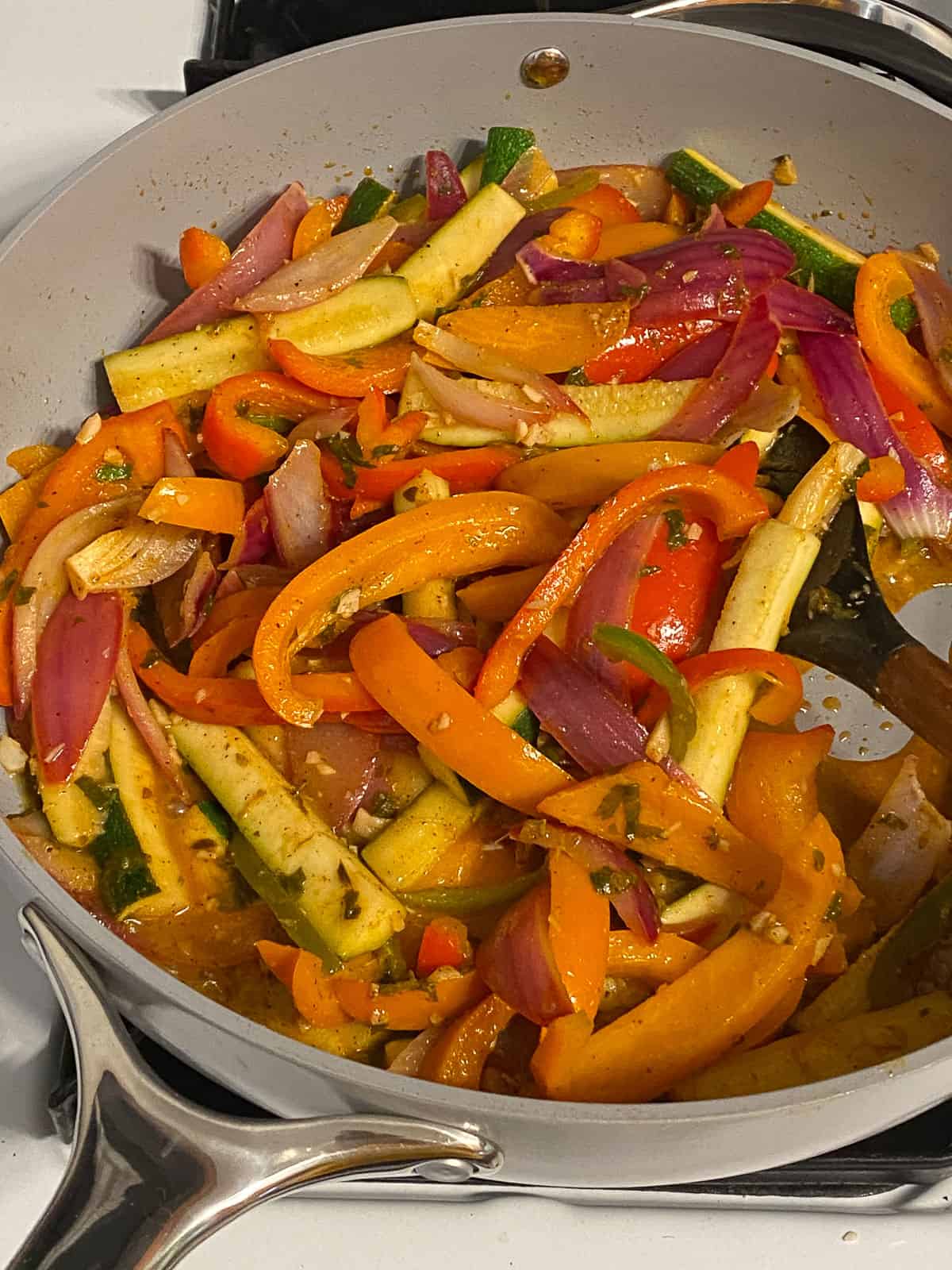 process shot of mixed veggies being cooked in a pan