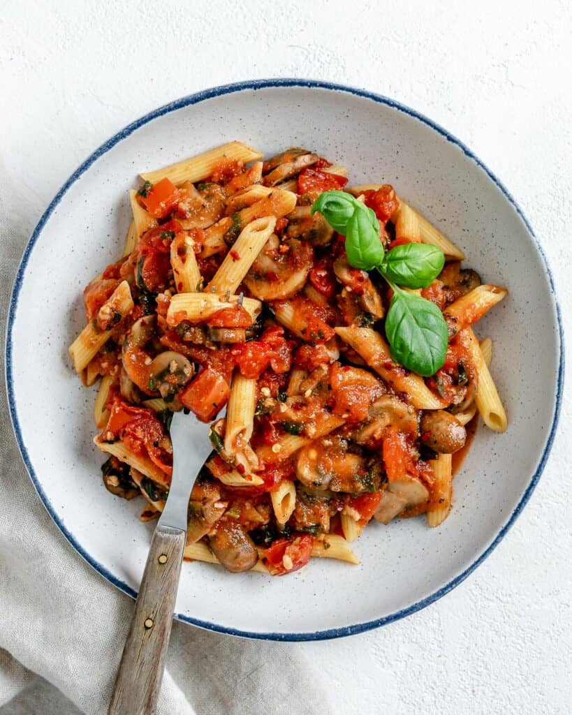 completed Spicy Tomato Basil Pasta in a white plate against a white surface