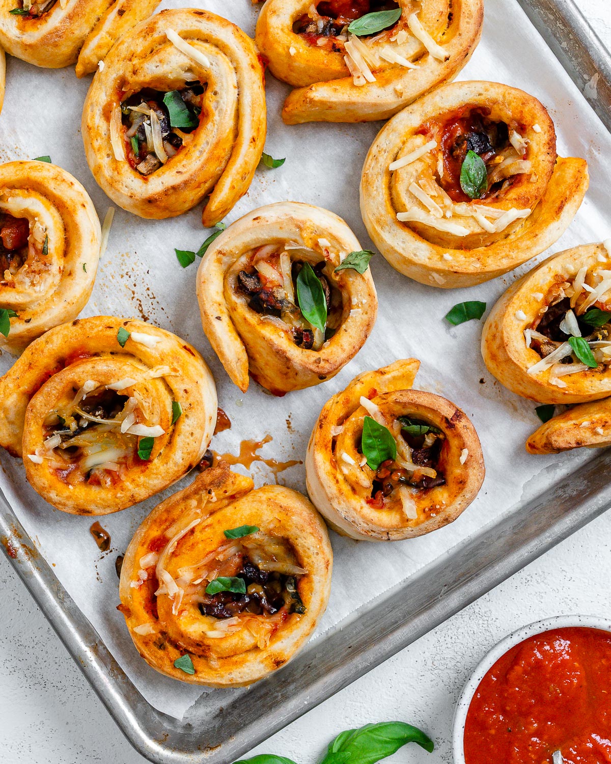 several completed vegan pizza rolls on a baking dish