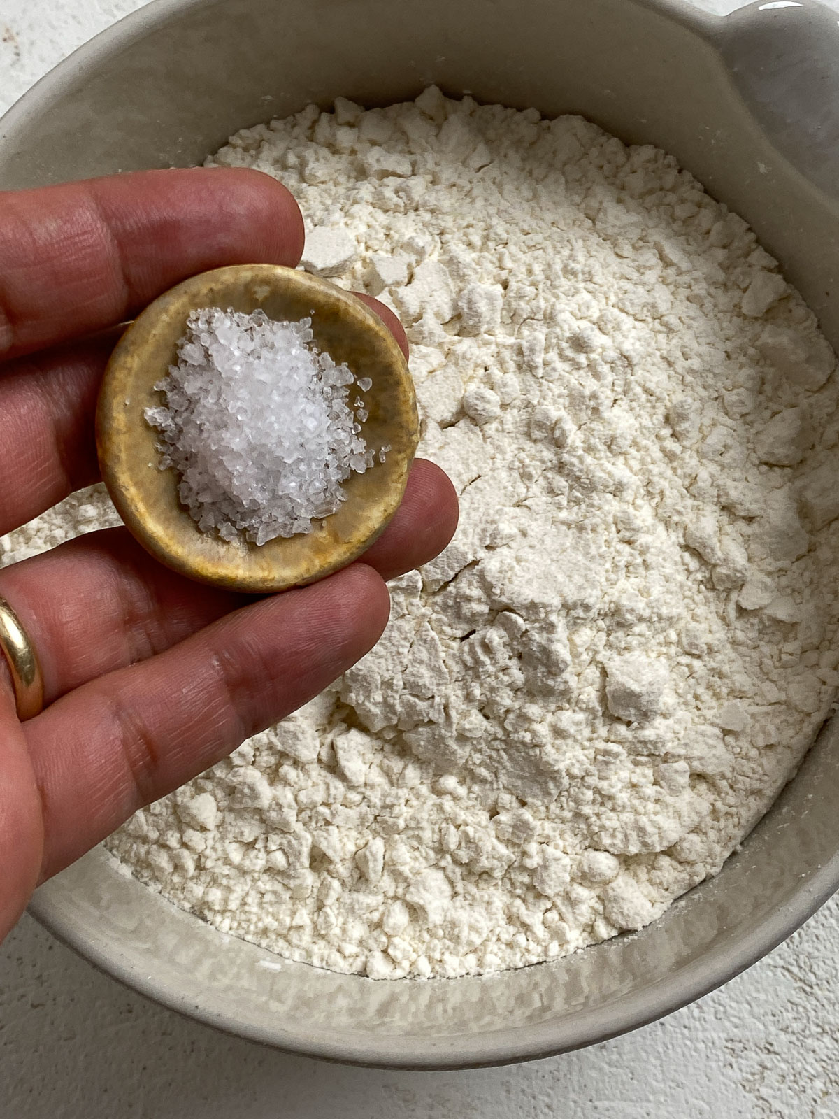 adding salt to bowl of flour in a bowl