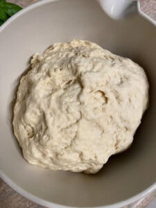 process of forming flour in a white bowl against a light brown surface