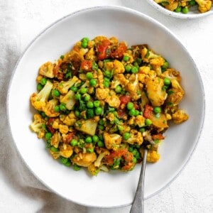 complete Aloo Gobi (Curried Potatoes, Cauliflower, and Peas) in a white bowl
