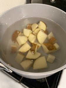 process of putting chopped potatoes in a bowl
