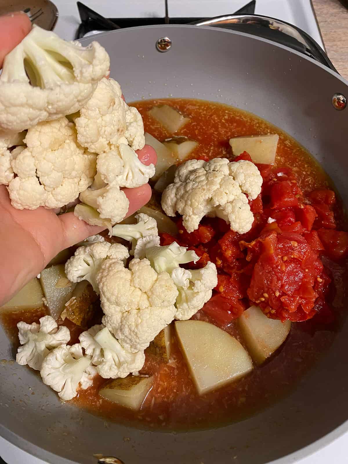 process of adding cauliflower to pan