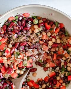 process of mixing ingredients of mixed bean salad in bowl