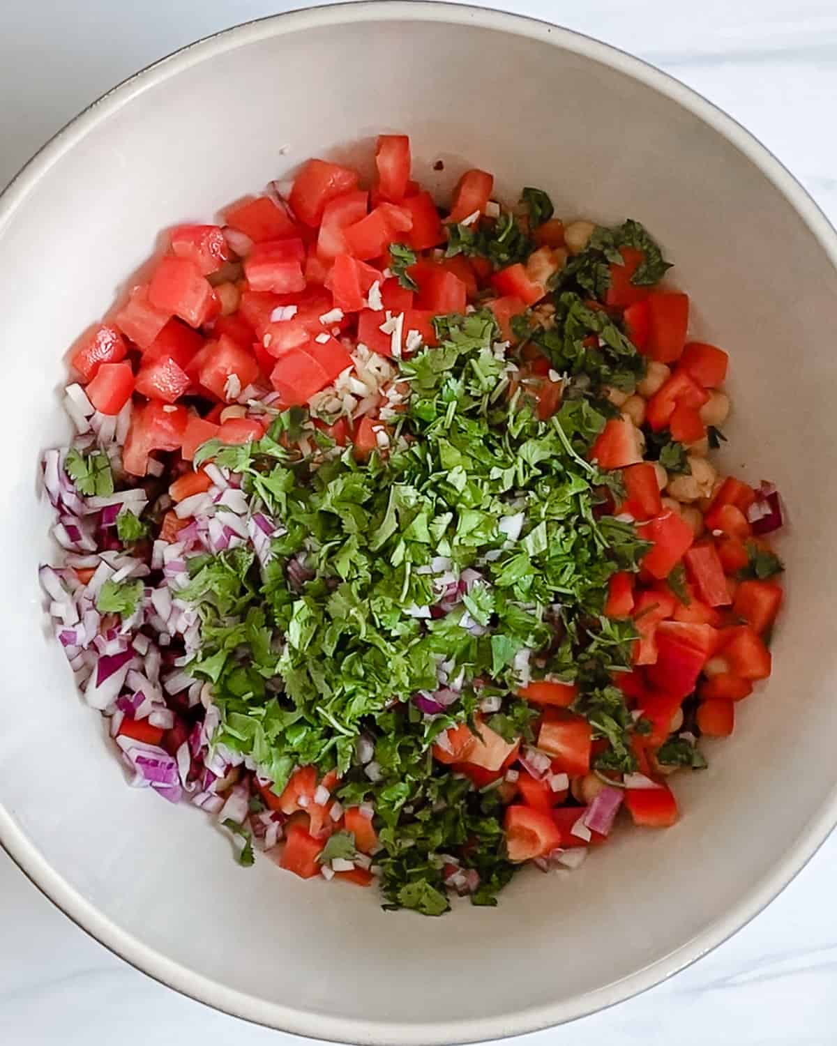process of adding additional ingredients to a white bowl