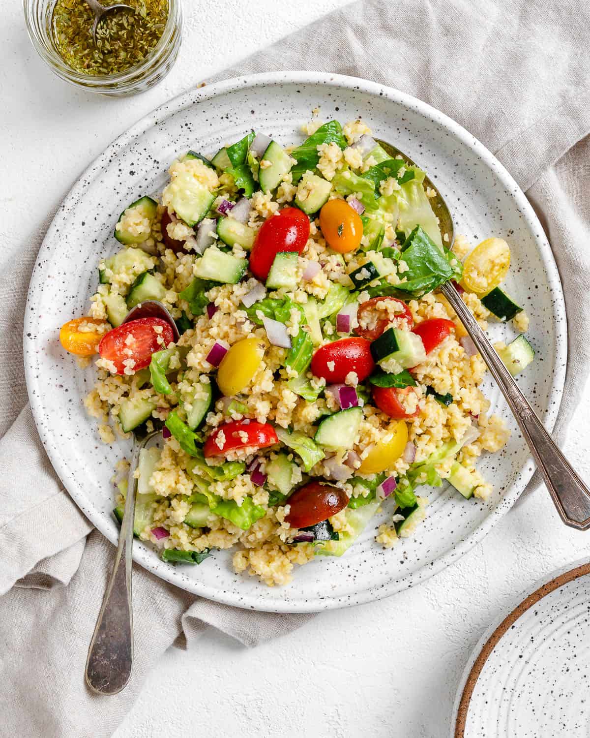 completed Vegan Greek Millet Salad on a white plate against a light background
