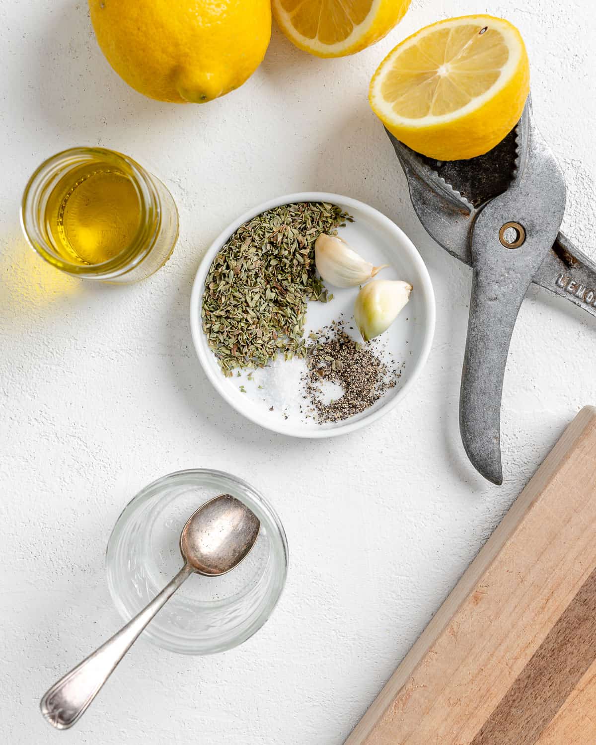 process of mixing spices and lemon into a small white bowl against a white background