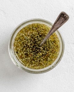 process of mixing spices and lemon into a small white bowl against a white background