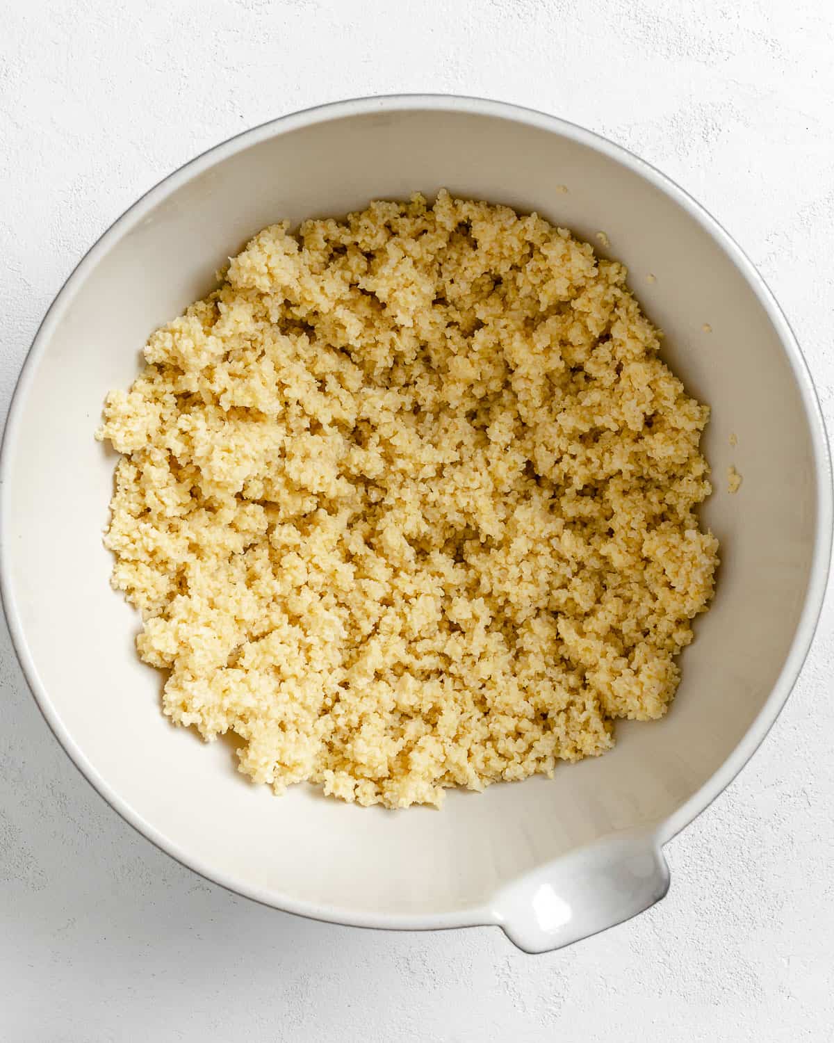 cooked millet in a white bowl against a white background