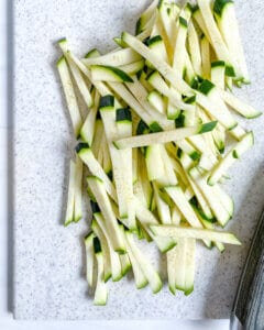 Soba Salad with Cucumbers Zucchini preparation with sliced cucumber on cutting board